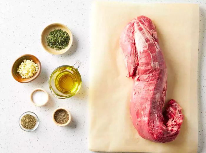 Ingredients for Grilled Beef Tenderloin with Herb-Garlic-Pepper Coating displayed on a white countertop.