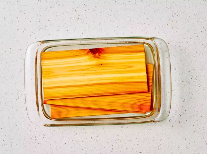 A small glass dish filled with water and cedar planks