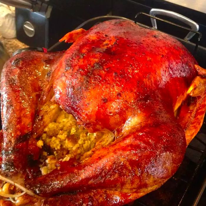 a beautifully golden turkey, stuffed and roasted to perfection in a pan