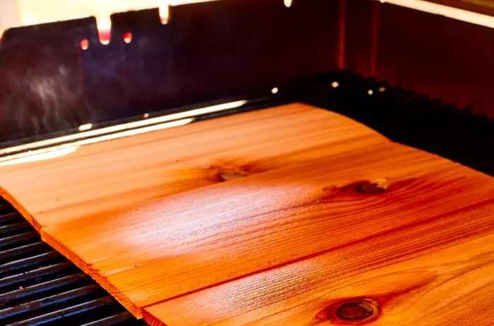 Soaked cedar planks resting on the grill grates