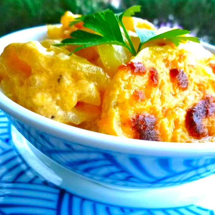 cheesy scalloped potatoes served in a white and blue dish