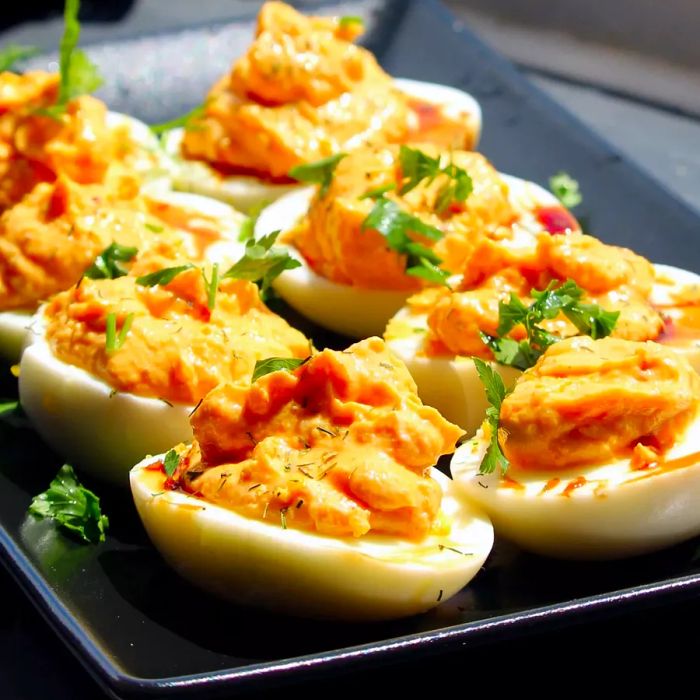A mid-angle view of a tray filled with harissa-spiced deviled eggs