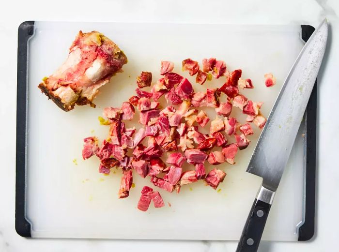 Diced ham bone resting on a cutting board.