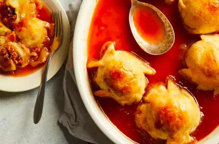 Homemade apple dumplings baked in a sweet sauce in a baking dish create a mouthwatering dessert.