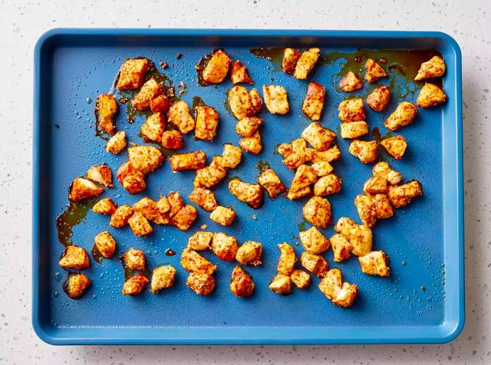 Chicken pieces coated with fajita seasoning and roasted on a baking sheet