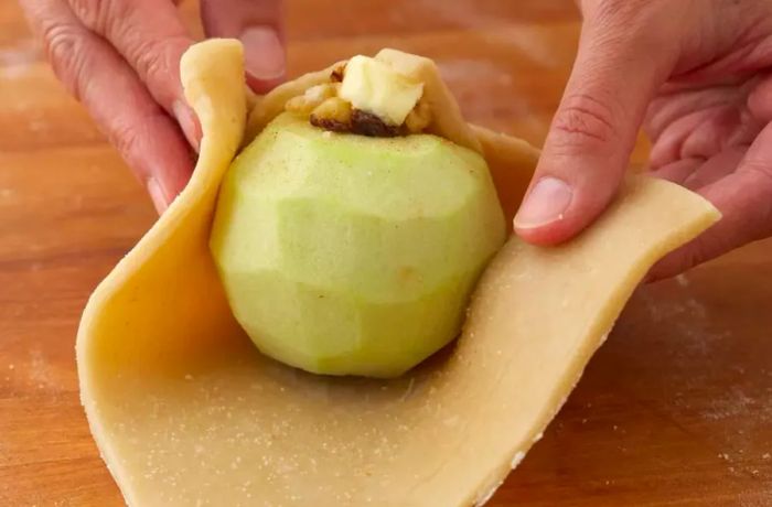 Wrapping a whole apple with pie crust to make apple dumplings creates a striking and classic presentation.