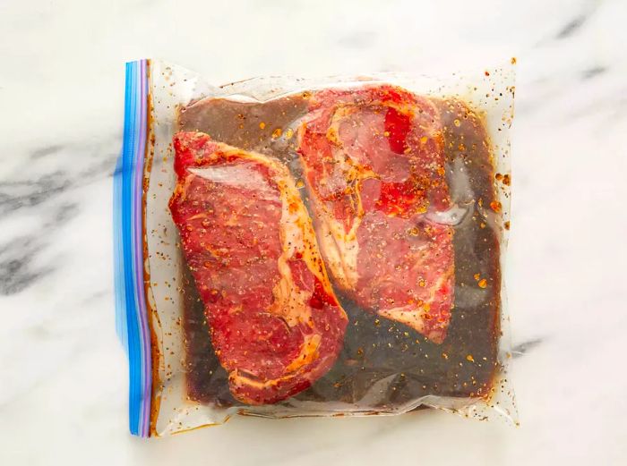 Top view of two steaks soaking in a resealable bag.