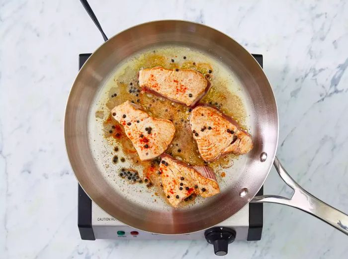 Overhead view of cooked tuna steaks in a skillet