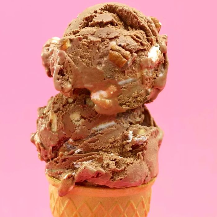 Scoops of homemade Rocky Road ice cream stacked in a crispy cone