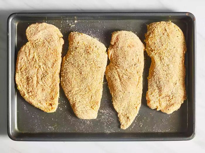 Chicken placed onto the hot baking sheet.