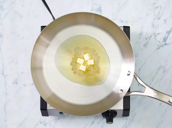 Top-down view of butter melting in a pan