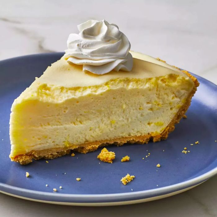 A slice of lemon chiffon pie topped with whipped cream