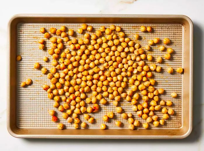 Chickpeas spread evenly across the baking sheet.