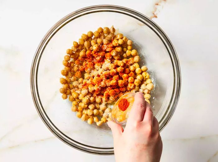 Seasoning being sprinkled into the bowl.