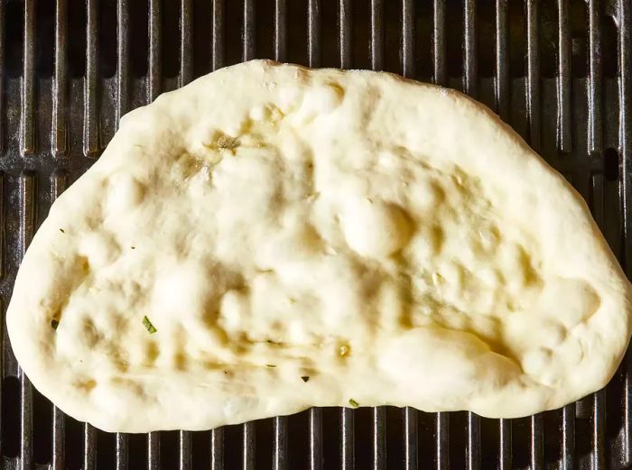 Dough placed on the grill, flipping it when the bottom is browned.