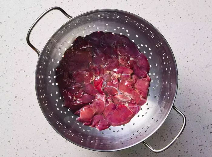 Colander filled with rinsed chicken livers