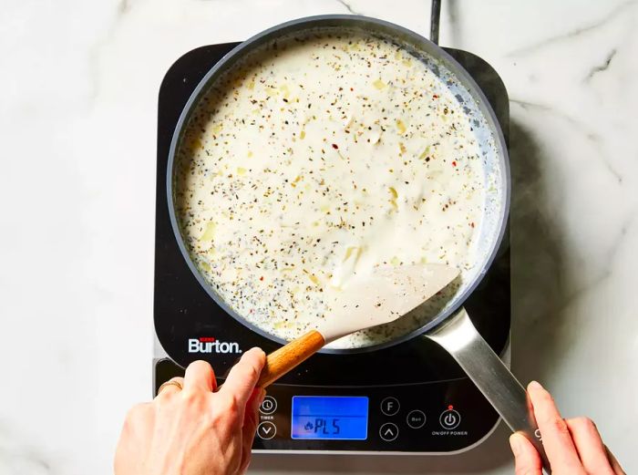 Flour and milk are added to the skillet, stirring until the mixture thickens.