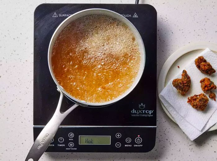 Frying dredged chicken livers in a small pot of hot oil