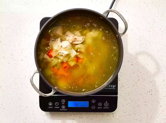 Chopped chicken and vegetables placed back into the pot