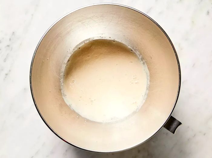 A top-down view of water and yeast in a mixing bowl.