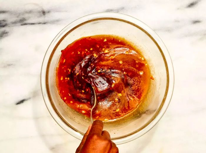 A small bowl of garlic-vinegar sauce being mixed together