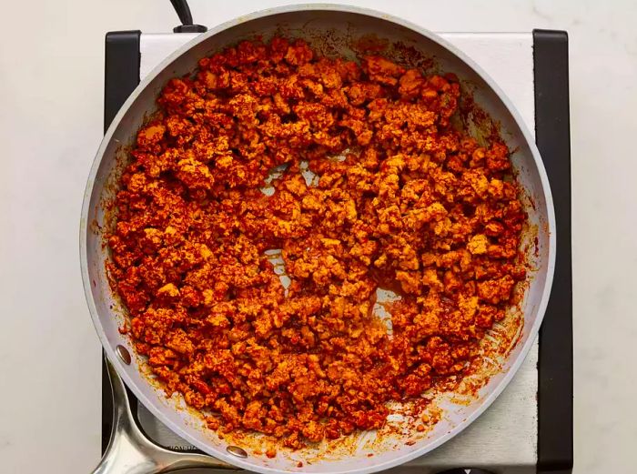 A large skillet filled with cooked ground turkey taco meat