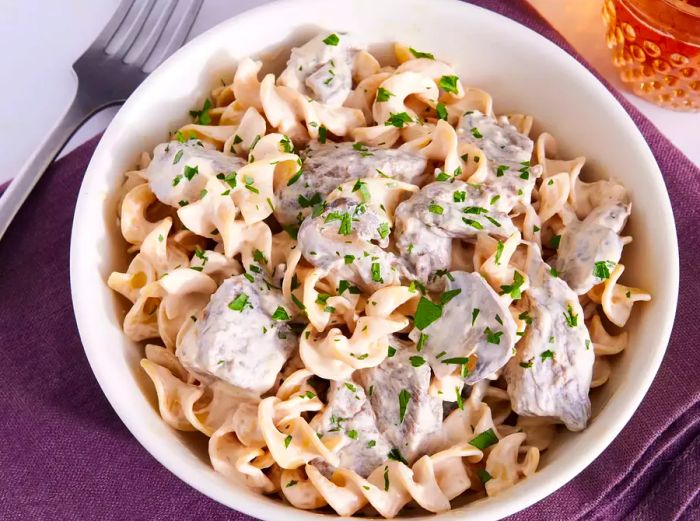 A bowl of Beef Stroganoff made in the Instant Pot, topped with freshly chopped parsley