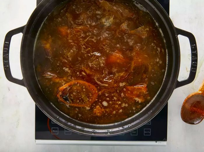 Place the beef bones and onion halves in a large stockpot. Add ginger, salt, star anise, fish sauce, and water. Bring the mixture to a boil, then reduce the heat and let it simmer.