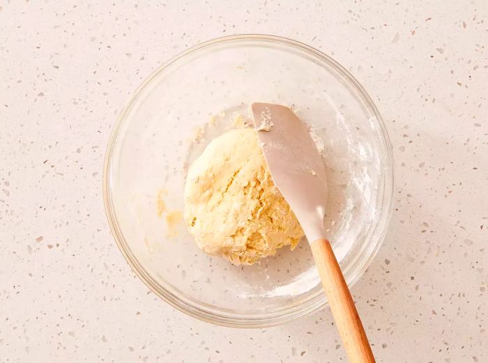 A glass bowl containing a ball of dough