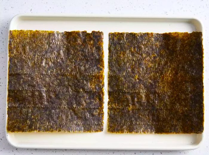 An aerial view of nori sheets arranged neatly on a plate