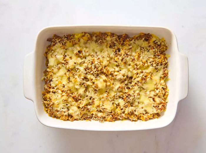 A casserole dish of Big Mac casserole, golden and bubbly with melted cheese on top