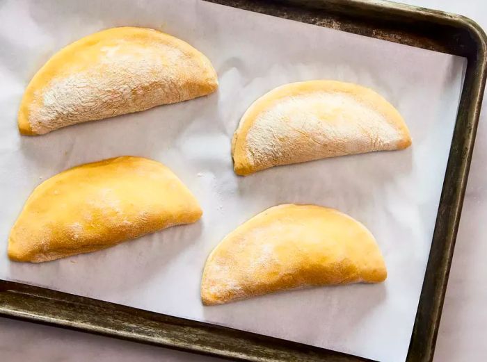 pierogi laid out on a baking sheet to freeze