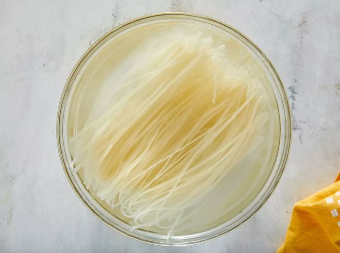 Rice noodles placed in a large bowl filled with room temperature water.