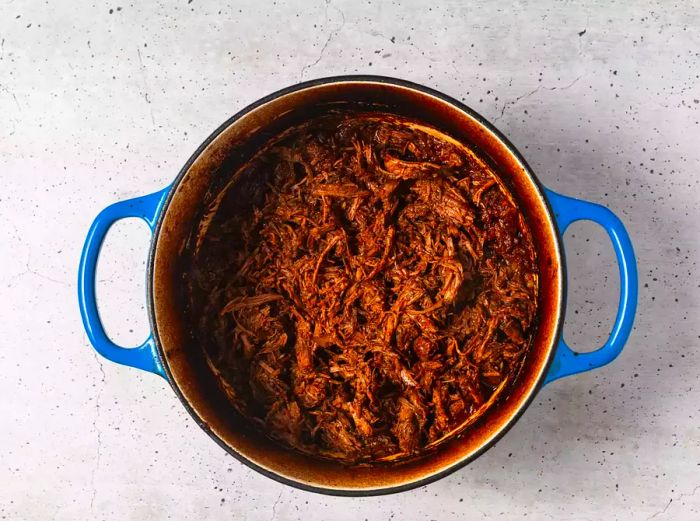 A pot with shredded beef coated in chili sauce