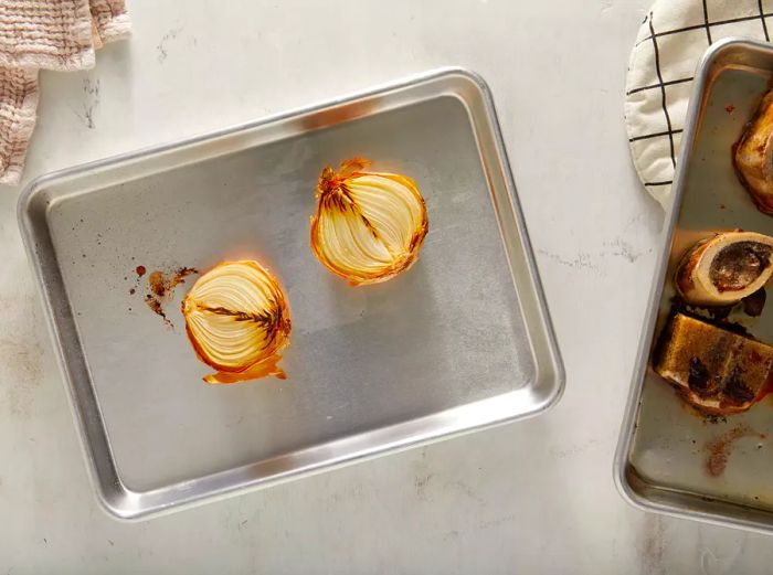 Onion halves placed on a baking sheet, roasted until charred and softened.