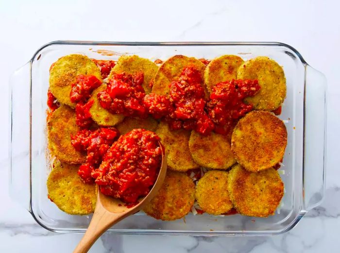 Pouring meat sauce over the eggplant layer