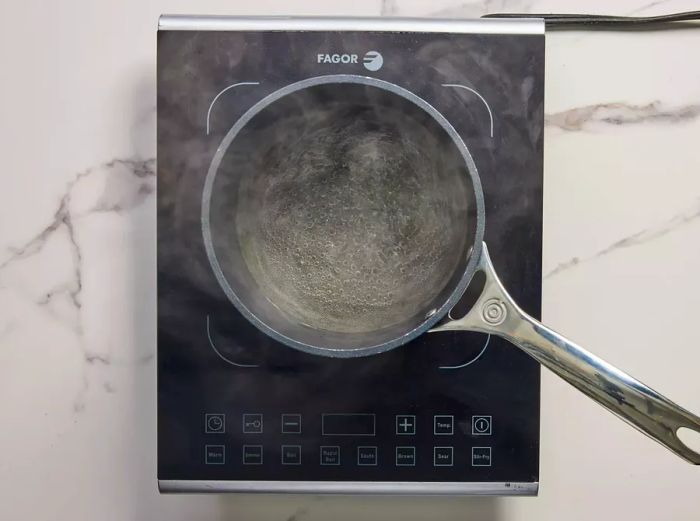 A small pot simmering with rice vinegar, water, and sugar