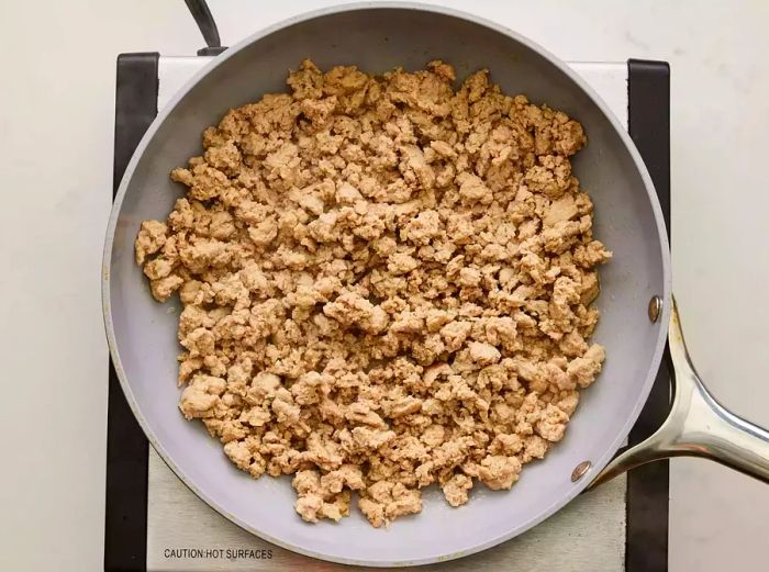 A large skillet filled with cooked ground turkey