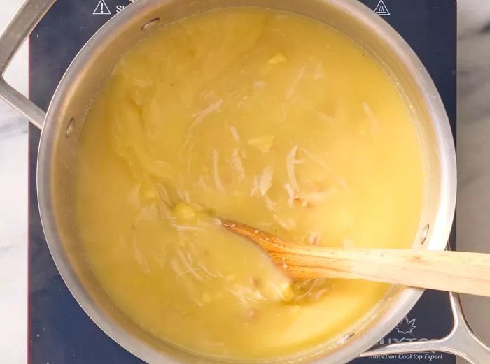 Condensed soup, chicken broth, and shredded chicken mixed in a large saucepan