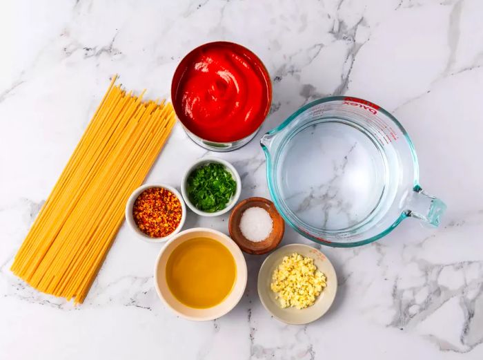 Bowls filled with the essential ingredients for making Spaghetti all'Assassina.