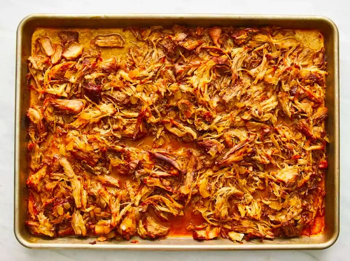 Place the pork on a baking sheet and bake until browned, shredding it as it cooks to perfection.