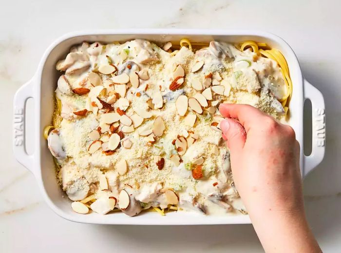 Turkey mixture placed over pasta, then garnished with cheese and sliced almonds