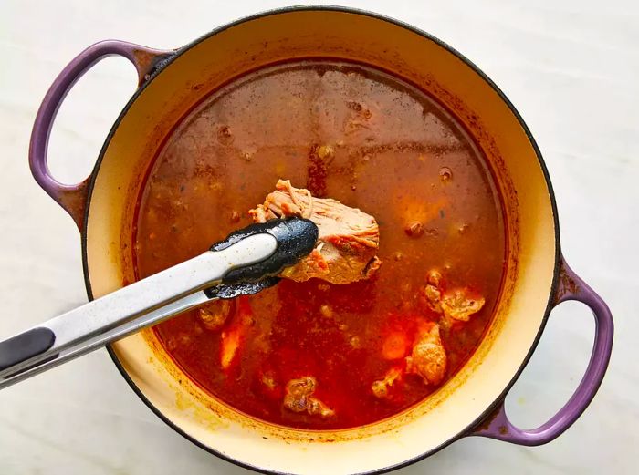 Add the remaining ingredients and pour in the chicken broth. Bring to a boil and cook until the pork becomes tender.