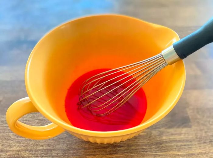 Jell-O and hot water in a mixing bowl, ready to be whisked together