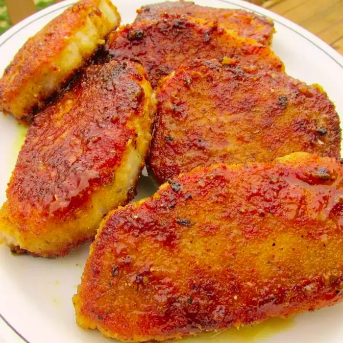 Close-up shot of Canadian Pork Loin Chops arranged on a white platter.