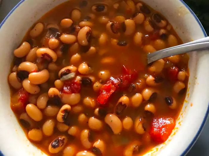 A close-up shot of New Year's Black-Eyed Peas served in a bowl with a spoon