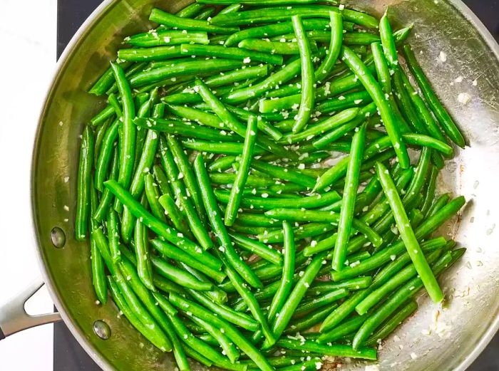 Aerial view of green beans with garlic in a pan