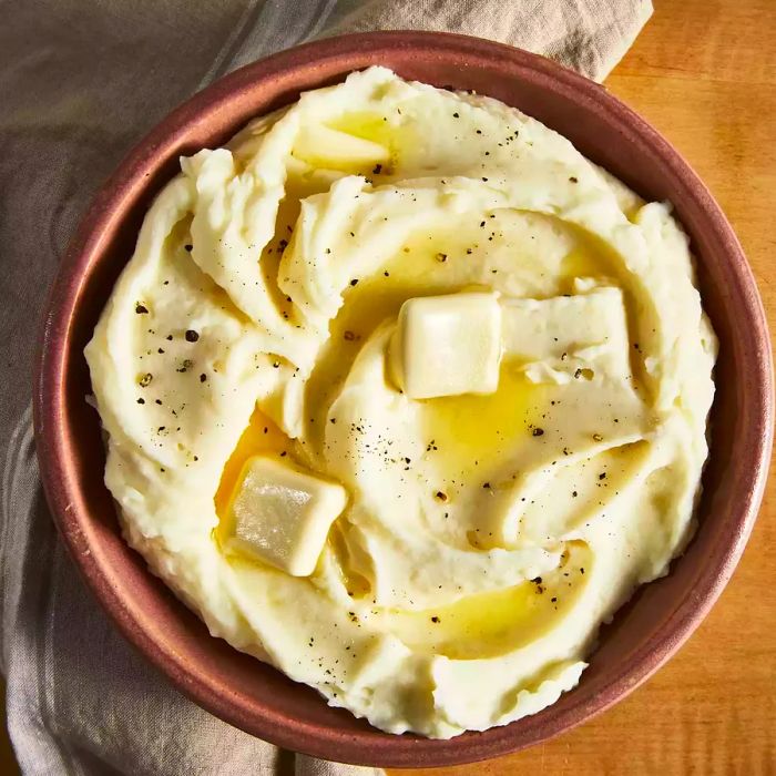 An overhead view of a large bowl filled with creamy, buttery mashed potatoes