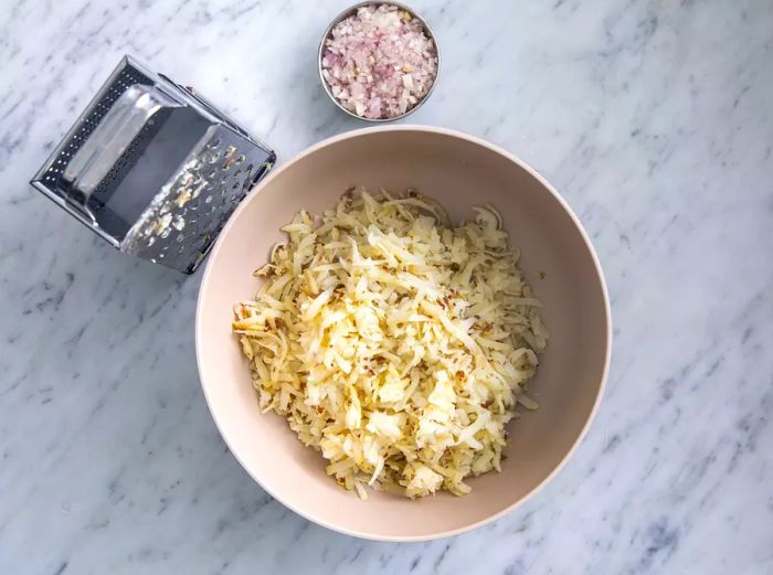 Shredded baked potatoes ready to be mixed.