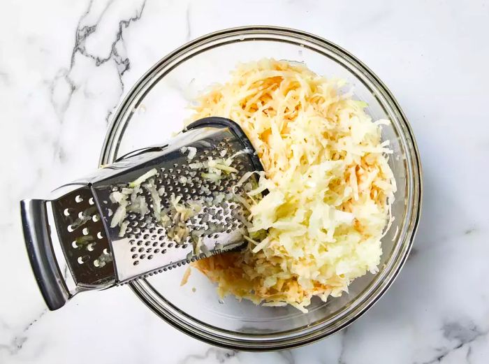 finely grated potatoes and onions in a bowl